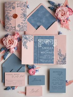 the wedding stationery is laid out with pink flowers and blue envelopes on top