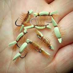 five different types of fishing lures on a person's hand with their fingers in the air