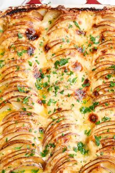 a casserole dish with potatoes and parsley on top, ready to be eaten