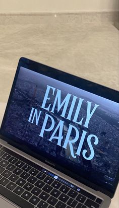 an open laptop computer sitting on top of a white table with the words family in paris printed on it