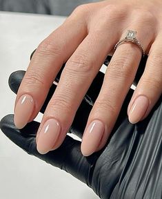 a woman's manicured nails with a diamond ring on her finger and black gloves