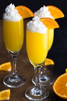 two glasses filled with orange juice and whipped cream