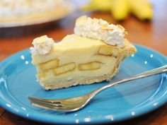 a piece of cheesecake on a blue plate with a fork and bananas in the background