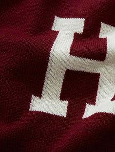 a maroon and white knitted sweater with the letter h on it's chest