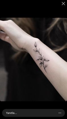 a woman's arm with a small flower tattoo on the left side of her arm