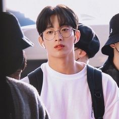 the young man is wearing glasses and a white t - shirt