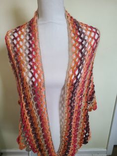 This a hand crocheted shawl in done in the V-shape style.  The "Autumn Day" shawl is a wonderful striped blending of brown, tan, pink and orange colors.  This accessory may  be worn anywhere.  The measurements are 64 inches wide from tip to tip and is  33 inches from nape of neck to point. Being made of acrylic yarn, the shawl is machine washable and dryable.  Please No Iron. Crochet Shawl For Fall, One Size, Crochet Shawl For Fall, One Size Crochet Shawl For Fall, Fall Beach Crochet Shawl, Fall Beach Shawl With Crochet Details, Bohemian Crochet Lace Shawl Pattern, Bohemian Crochet Lace Patterns In Yarn, Crochet Shawl Patterns In Yarn, Crochet Yarn Shawl Patterns