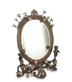 an ornately decorated mirror with cherubs and flowers on the frame, against a white background