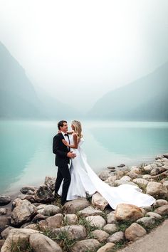 Bride and groom standing in front of the Fairmont Chateau Lake Louise in Banff National Park, Canada. Light blue smoky water. Destination Wedding Photographer. Banff wedding. Banff Canada Elopement Photographer. Banff Canada Wedding photographer. Alberta Wedding Photographer. Alberta Elopement photographer. Banff national park elopement wedding Photographer. Lake Louise Wedding. Banff National Park Wedding Photographer. Lake Moraine Wedding. Fairmont Lake Louise, Digital Designer, Destination Wedding Photos, National Park Wedding