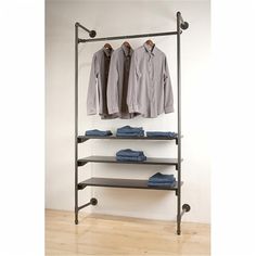 an industrial style clothing rack with three shelves and two shirts hanging on the rails