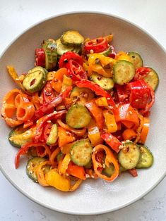 a white bowl filled with vegetables on top of a table