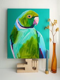 a painting of a green parrot on a wooden block next to a vase with flowers