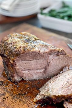 a piece of meat on a cutting board with a knife and fork next to it