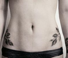 a woman's lower body with tattoos on her stomach and the bottom part of her abdomen