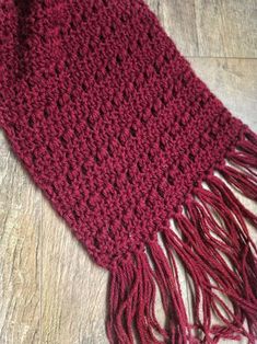 a close up of a red scarf on a wooden floor