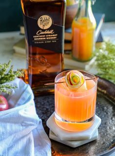 an orange drink in a glass on a table