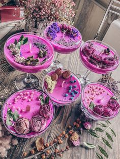 several bowls filled with flowers on top of a wooden table