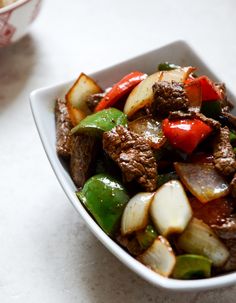 a close up of a bowl of food with meat and vegetables