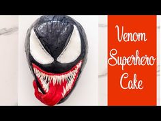 a close up of a mask on a wall with the words venom superhero cake written above it