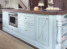 a kitchen with blue cabinets and an island in the middle is decorated with white dishes