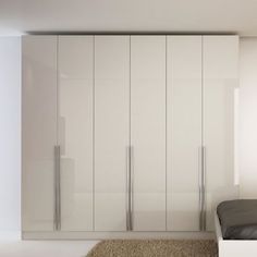 a bedroom with white closets and carpeted flooring