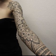 a woman's arm with an intricate tattoo design on the left side of her arm