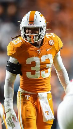 a close up of a football player wearing an orange uniform