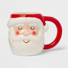 a red and white santa claus mug with eyes closed