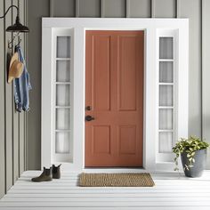 a white front door with two shelves on the side and a potted plant next to it