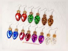 ❤️ NEW! Earrings will now include a glossy topcoat for EXTRA shine! 🎄 Christmas glitter light bulb earrings that'll be SO fun to wear for the holiday season! Available in 7 STUNNING shimmering colors! Collect them all! 🎅 🎄- Other favorite items available through my shop link! https://www.etsy.com/shop/socreativevibes/ 🎄Drop length - Close to 2.5 inches 🎄Bulb width - 1/2 inch 🎄Bulb height - 1.5 inches 🎅 Earring hooks are hypoallergenic and friendly to sensitivity. Earring backs are clear r Shrinky Dink Earrings, Multiple Earrings, Christmas Glitter, Holiday Earrings, Corpus Christi Tx, Earrings Resin, New Earrings, Earrings Christmas, Holiday Earring