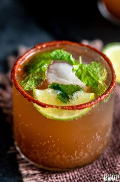 a close up of a drink in a glass with ice and mint garnish