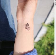 a small butterfly tattoo on the wrist