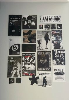 a white wall covered in posters and stickers with the words i am music on them