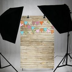 two umbrellas sitting next to each other in front of a wooden wall with flags on it