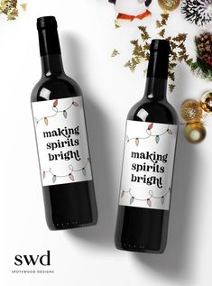 two bottles of red wine sitting next to each other on a table with christmas decorations