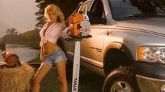 a woman standing next to a truck holding a saw