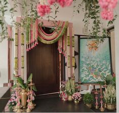 an entrance decorated with pink flowers and greenery