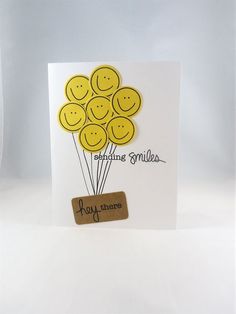 a card with some smiley faces on it and a tag hanging from the bottom that says happiness smiles