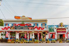 an old fashioned building with many flags and decorations on the front, along with other buildings