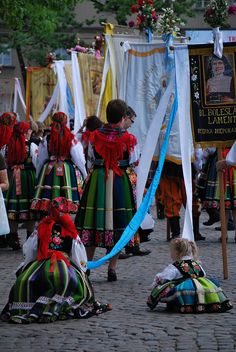 several people in colorful dresses are sitting on the ground