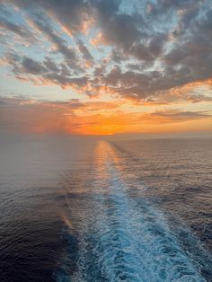 the wake of a boat in the ocean at sunset