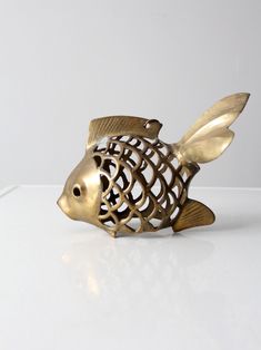 a gold fish sculpture sitting on top of a white table