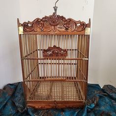 an old wooden birdcage sitting on top of a blue blanket