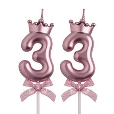 two pink birthday candles with the number three on top