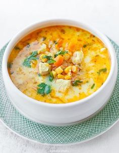 a white bowl filled with soup on top of a green plate