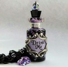 a bottle that has some kind of purple liquid in it and is next to a chain