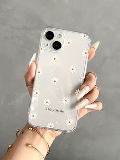 a woman's hand holding an iphone case with daisy daisies on it,