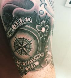 a man's arm with a compass tattoo on it