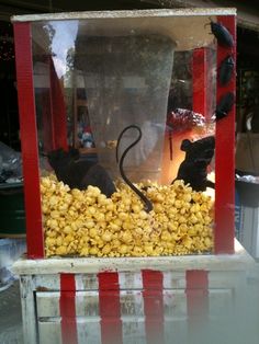 a popcorn machine filled with corn and an umbrella shaped like a cat sitting on top of it