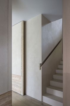 an empty room with white walls and stairs